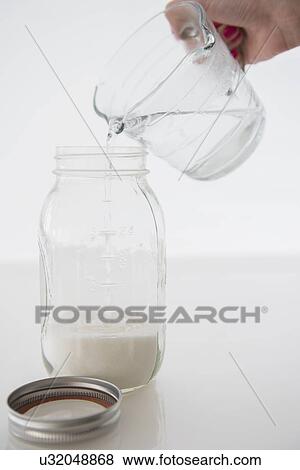 Stock Photo - Woman mixing milk with water. Fotosearch