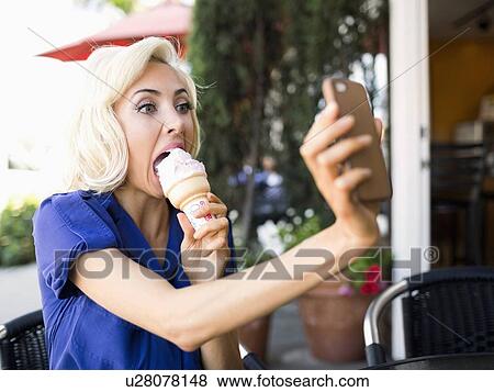 Woman photographing herself with ice-cream View Large Photo Image Stock Photo - Woman photographing herself with ice-cream. Fotosearch