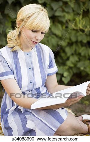 Woman reading book in garden View Large Photo Image Stock Image - Woman reading book in garden. Fotosearch