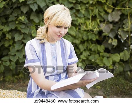 Woman reading book in garden View Large Photo Image Stock Image - Woman reading book in garden. Fotosearch