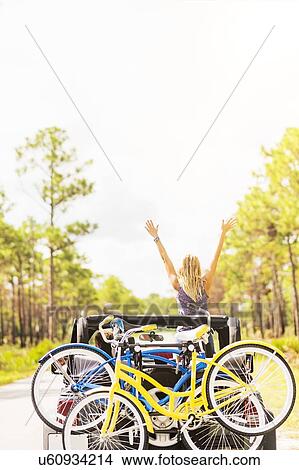 Picture - Woman rising hands in car. Fotosearch