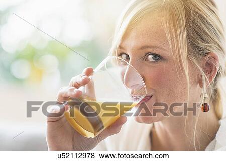 Woman sitting in living room and drinking orange juice View Large Photo Image Stock Photo - Woman sitting in living room and drinking orange juice. Fotosearch