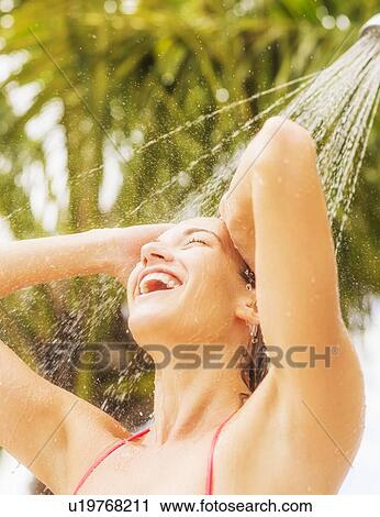 Stock Image - Woman taking shower outdoors. Fotosearch