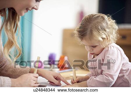 Woman teaching young girl at home View Large Photo Image Picture - Woman teaching young girl at home. Fotosearch