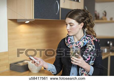 Woman using phone in kitchen View Large Photo Image Stock Image - Woman using phone in kitchen. Fotosearch