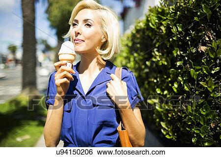 Woman walking with ice-cream View Large Photo Image Stock Photograph - Woman walking with ice-cream. Fotosearch