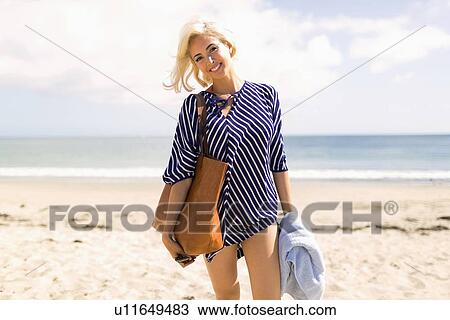 Woman wearing striped blouse posing on sandy beach View Large Photo Image Stock Image - Woman wearing striped blouse posing on sandy beach. Fotosearch