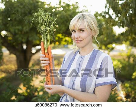 Woman wearing striped dress working in vegetable garden View Large Photo Image Stock Image - Woman wearing striped dress working in vegetable garden. Fotosearch