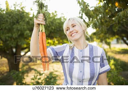 Woman wearing striped dress working in vegetable garden View Large Photo Image Stock Image - Woman wearing striped dress working in vegetable garden. Fotosearch