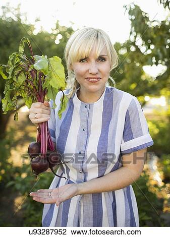 Woman wearing striped dress working in vegetable garden View Large Photo Image Stock Image - Woman wearing striped dress working in vegetable garden. Fotosearch