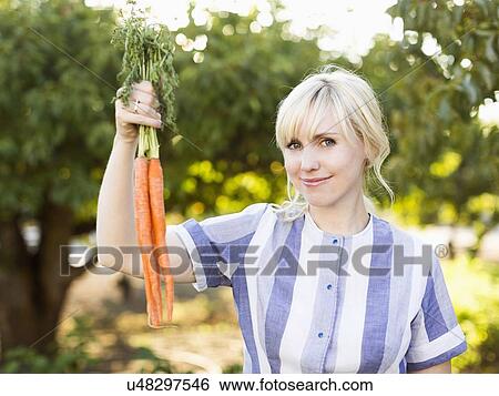 Woman wearing striped dress working in vegetable garden View Large Photo Image Stock Photograph - Woman wearing striped dress working in vegetable garden. Fotosearch