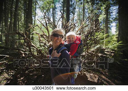 Stock Image - Woman with son (4-5) on trail of cedars. Fotosearch