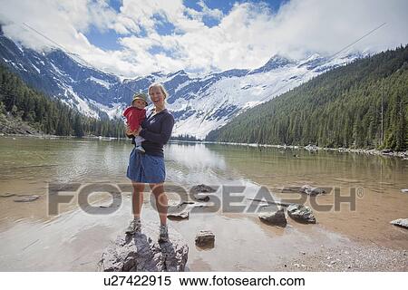 Stock Photography - Woman with son (4-5) standing on lakeshore. Fotosearch