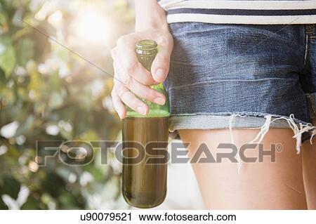 Stock Image - Woman's hand holding beer bottle. Fotosearch