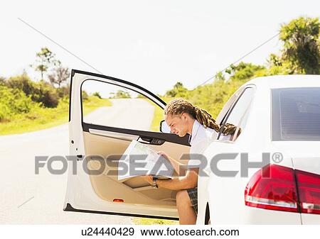 Young man checking map View Large Photo Image Stock Photo - Young man checking map. Fotosearch