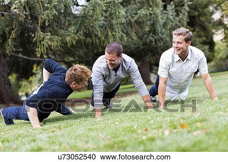 Young man doing push ups in park View Large Photo Image Stock Image - Young man doing push ups in park. Fotosearch
