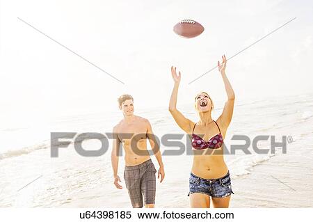 Young woman catching football on beach View Large Photo Image Stock Photography - Young woman catching football on beach. Fotosearch