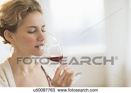 Stock Image - Young woman drinking red wine. Fotosearch