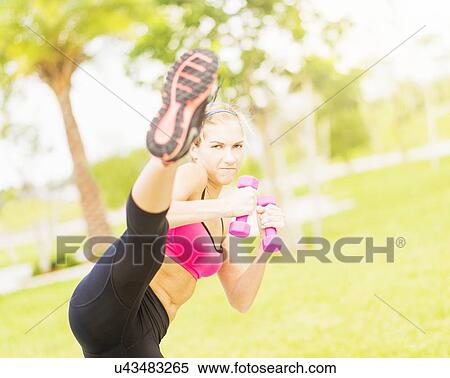 Young woman exercising in park using dumbbells View Large Photo Image Stock Photography - Young woman exercising in park using dumbbells. Fotosearch