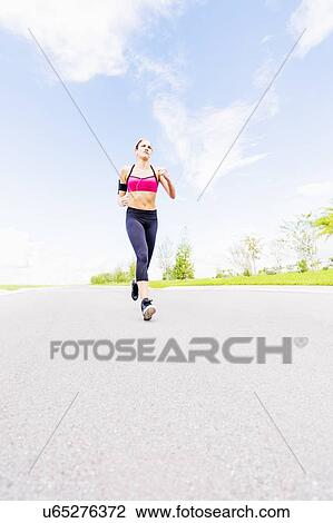 Young woman jogging in park View Large Photo Image Stock Image - Young woman jogging in park. Fotosearch