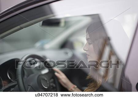 Young woman sitting in car View Large Photo Image Stock Photo - Young woman sitting in car. Fotosearch
