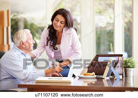 Stock Image - Adult Daughter Helping Father With Laptop. Fotosearch