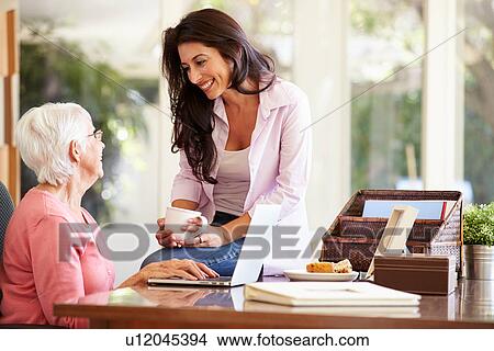 Picture - Adult Daughter Helping Mother With Laptop. Fotosearch