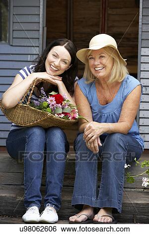 Adult mother and daughter sitting on veranda View Large Photo Image Stock Photograph - Adult mother and daughter sitting on veranda. Fotosearch