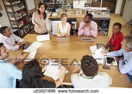 Architects Sitting At Table Meeting With Laptops And Tablets View Large Photo Image Stock Photograph - Architects Sitting At Table Meeting With Laptops And Tablets. Fotosearch