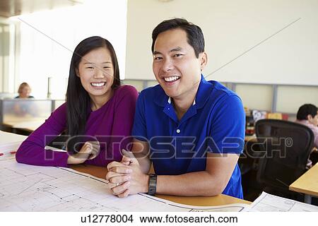 Picture - Architects Studying Plans In Modern Office Together. Fotosearch