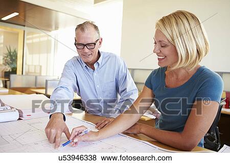 Stock Photo - Architects Studying Plans In Modern Office Together. Fotosearch