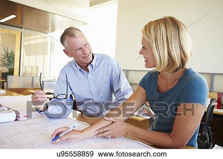 Stock Photo - Architects Studying Plans In Modern Office Together. Fotosearch