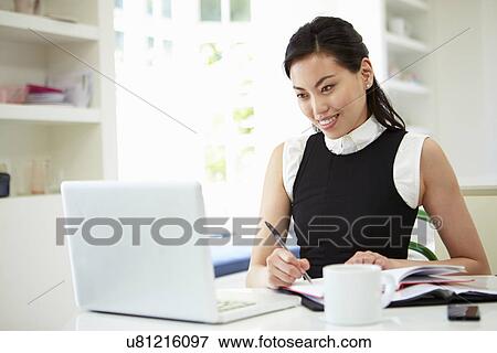 Stock Photo - Asian Businesswoman Working From Home On Laptop. Fotosearch