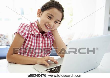 Stock Photograph - Asian Child Using Laptop At Home. Fotosearch