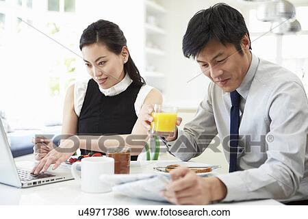 Asian Couple With Laptop And Newspaper At Breakfast View Large Photo Image Stock Photograph - Asian Couple With Laptop And Newspaper At Breakfast. Fotosearch