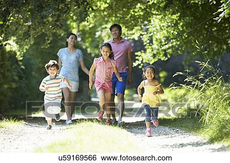 Stock Photograph - Asian Family Enjoying Walk In Countryside. Fotosearch