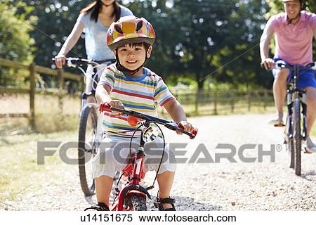 Stock Photography - Asian Family On Cycle Ride In Countryside. Fotosearch