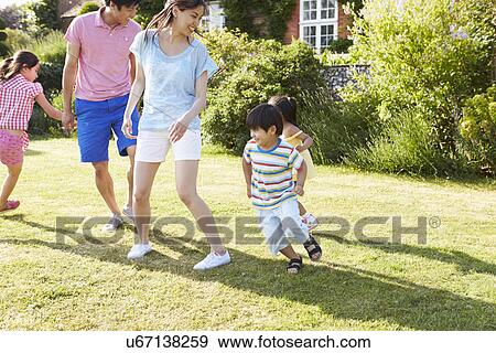 Asian Family Playing In Summer Garden Together View Large Photo Image Stock Photo - Asian Family Playing In Summer Garden Together. Fotosearch