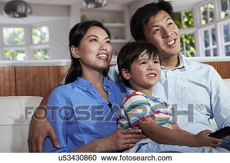 Asian Family Sitting On Sofa Watching TV Together View Large Photo Image Stock Image - Asian Family Sitting On Sofa Watching TV Together. Fotosearch