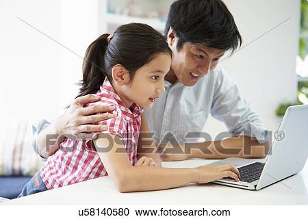 Asian Father Helping Daughter To Use Laptop At Home View Large Photo Image Stock Image - Asian Father Helping Daughter To Use Laptop At Home. Fotosearch