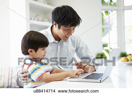 Asian Father Helping Son To Use Laptop At Home View Large Photo Image Picture - Asian Father Helping Son To Use Laptop At Home. Fotosearch