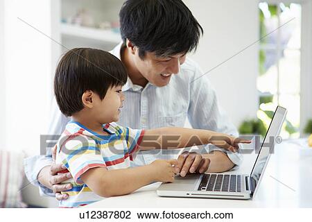 Asian Father Helping Son To Use Laptop At Home View Large Photo Image Stock Image - Asian Father Helping Son To Use Laptop At Home. Fotosearch