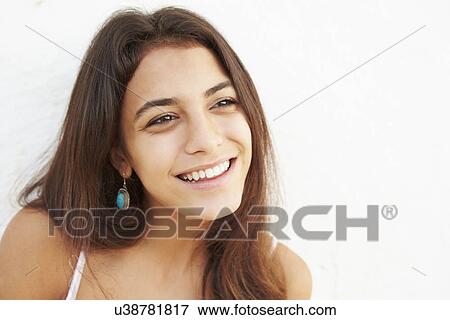 Stock Photo - Attractive Hispanic Teenage Girl Leaning Against Wall. Fotosearch