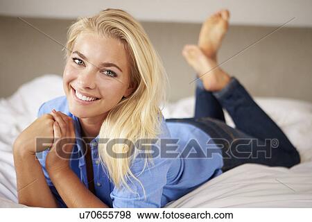 Stock Photo - Attractive Young Woman Lying On Bed. Fotosearch