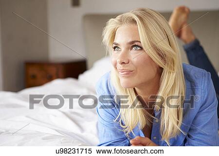 Stock Photography - Attractive Young Woman Lying On Bed. Fotosearch
