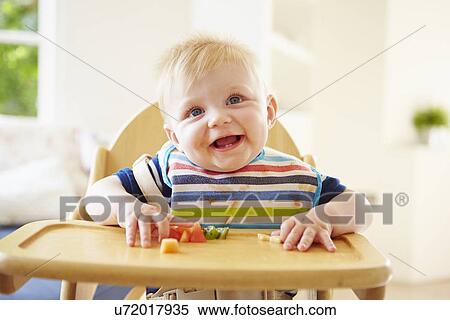Baby Boy Eating Fruit In High Chair View Large Photo Image Stock Photography - Baby Boy Eating Fruit In High Chair. Fotosearch