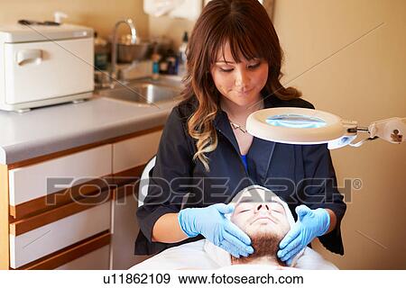 Stock Photo - Beautician Applying Cream To Male Client In Clinic. Fotosearch