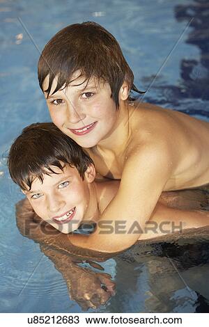 Stock Image - Boy and girl in swimming pool. Fotosearch