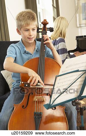 Stock Photo - Boy and girl playing cello and piano at home. Fotosearch