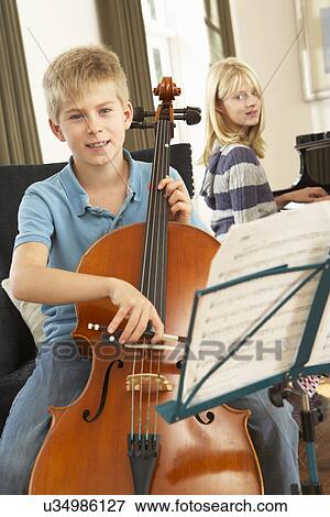 Boy and girl playing cello and piano at home View Large Photo Image Stock Photo - Boy and girl playing cello and piano at home. Fotosearch